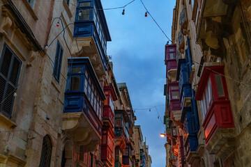 Colorful Maltese Balconies Facing Each Other with Festoon Lights at Dusk