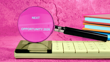 A magnifying glass shows the words NEXT OPPORTUNITY 2026 as it sits on top of a calculator with...