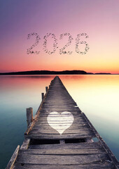 starting the new year 2026, wooden pier over sea with flying birds in shape of 2026