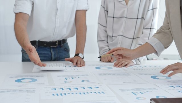 Group of business people is collaborating in modern office environment, analyzing financial data and charts, evaluating performance and developing company growth strategy - Powered by Adobe