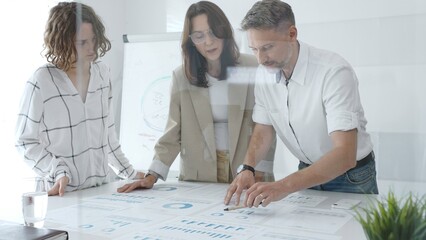 Professional team reviewing financial data, collaborating on working documents, demonstrating team achievements and positive dynamics in the workplace. Business people concept