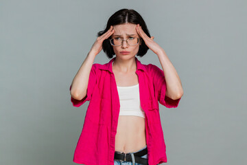 Naklejka premium Young woman sighs deeply, sadly shakes head covers face with hands reacting to failure bad news with visible disappointment. Caucasian girl expresses emotional frustration isolated on gray background