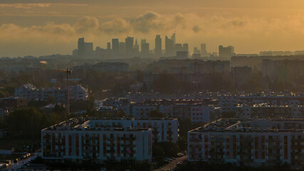 A distant view of Warsaw’s skyscrapers on a foggy autumn morning.