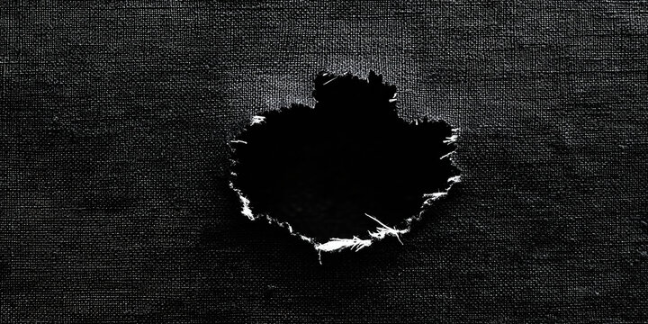 A dark fabric with a prominent hole showing empty space