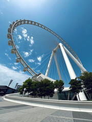 Giant Ferris wheel under blue sky, modern observation wheel architecture and urban landmark...