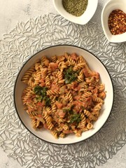 Red lentils fusilli pasta with peeled chopped tomatoes caramelized onion garlic spinach herbs and crushed dried red chillies.