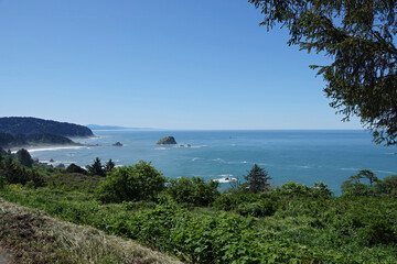 A scenic view of coastline at Crescent City , California , ocean meeting the shore with rocky islands, a sandy beach