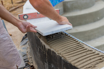 A technician lays tiles in a swimming pool. Selective focus.
