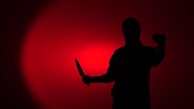 Silhouette assassin holding knife, Silhouette of a man holding a large kitchen knife