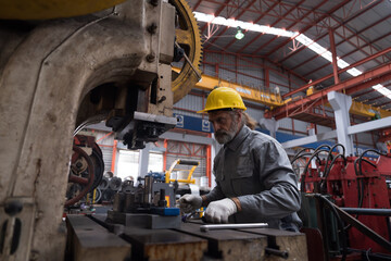 Senior male engineer, factory and lather machine. Male engineer at work in the industry factory, working with CNC machine. Male worker working with lathe machine