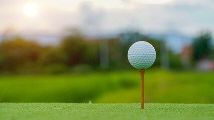 Golf clubs and golf balls on a green lawn in a beautiful golf course with morning sunshine.