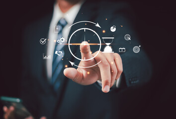 Businessman using time management tools and productivity icons on virtual screen to improve efficiency, planning and workflow optimization in modern digital workspace. Project manager concept.