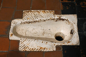 Sch&auml;bige, verschmutzte Hocktoilette