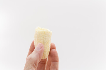 mano in primo piano che regge un pezzo di frutto di banana maturo isolati so sfondo bianco o trasparente