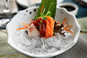 Sashimi fresco su ghiaccio con decorazioni vegetali in ciotola elegante