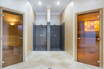 The bright lobby of the wellness center. Shower with partition. Glass doors to the hammam and sauna.