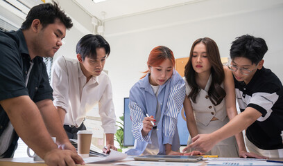 Creative business team meeting to brainstorm innovative ideas for a new venture, showing teamwork, leadership, and startup energy presentation project in a modern office. © saksit