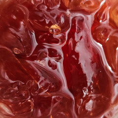 Macro texture of iced tea with amber color and melted ice reflections. 