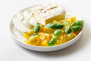 feta cheese with yellow tomatoes and basil