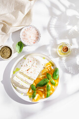 feta cheese with yellow tomatoes and basil
