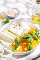 feta cheese with yellow tomatoes and basil