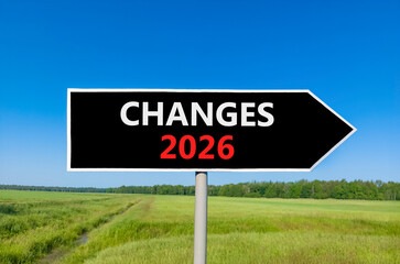 Changes 2026 symbol. Concept words Changes 2026 on beautiful black road sign. Beautiful green grass field forest and blue sky background. Business and changes 2026 concept. Copy space.