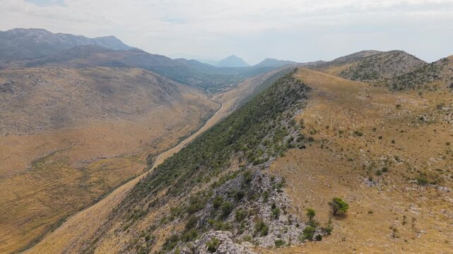 Ancient stone chapel on a coastal mountain ridge with panoramic sea view of the Dalmatian coast.
