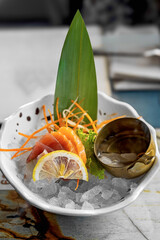 Sashimi fresco su ghiaccio con decorazioni vegetali in ciotola elegante