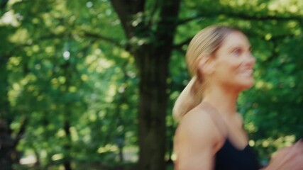 Smiling athletic woman jogging outdoors in green park