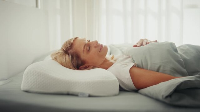 Peaceful woman resting on ergonomic memory foam pillow
