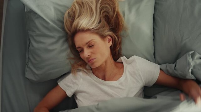 Woman waking up with neck pain in morning bed