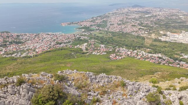 Ancient stone chapel on a coastal mountain ridge with panoramic sea view of the Dalmatian coast.