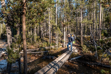Backpacker on a bridge over Hell Roaring Creek