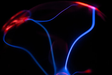 A vivid plasma ball glows in the dark, with electric pink and blue arcs radiating from its center, creating a mesmerizing visual of energy and science.