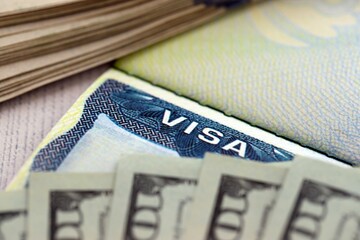 Fee for US visa 250 dollars, USA Visa in passport and USD money bills in background