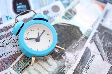 Egyptian pound currency money bills and alarm clock. The concept of time management and income