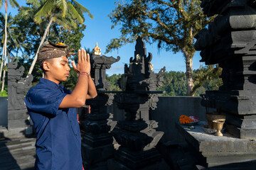 Side view of Balinese young man praying at Hindu shrine, Sidemen, Bali Indonesia. © cn0ra