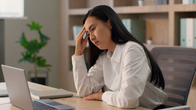 Tired upset Asian Japanese office worker employer business woman Chinese Korean female businesswoman entrepreneur close laptop desktop computer end job depressed burnout mental health problems indoor