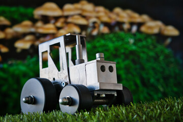 A whimsical macro scene where a toy tractor meets a mushroom forest—blending childhood, fantasy, and industry in a playful visual metaphor. Ideal for themes of creativity, storytelling, and innovation