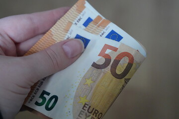 Close-up of a Hand Clutching a Stack of €50 Euro Banknotes, Symbolizing Saving, European Money, Wealth, and Transaction