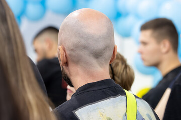 Back of a Man's Shaved Head in a Crowd at an Event or Conference. Audience Focus