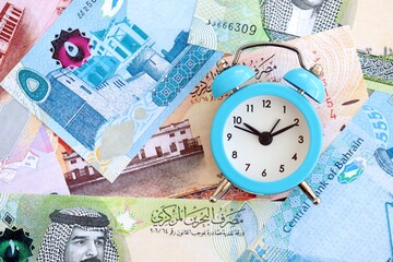 Bahraini dinar currency money bills and alarm clock. The concept of time management and income