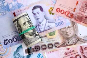 Thai baht currency money bills and bunch of us dollars. The concept of currency exchange