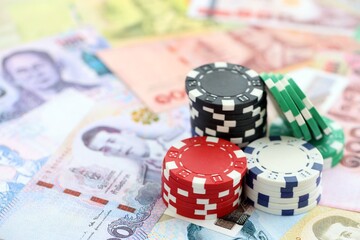 Thai baht currency money bills and bunch of casino chips. The concept of gambling and casino