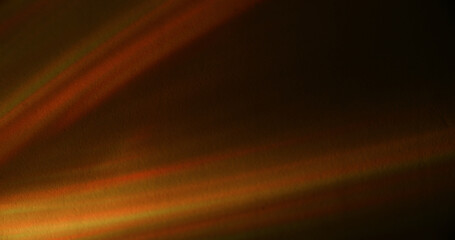 Defocused light rays. Color glare. Orange yellow green radiant texture optical flash flare beam on abstract illuminated dark black art background.