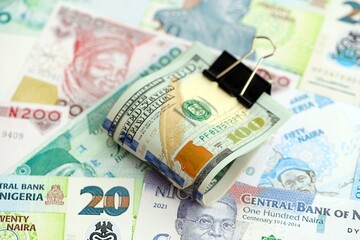 Nigerian naira currency money bills and bunch of us dollar banknotes. The concept of economics and currency exchange