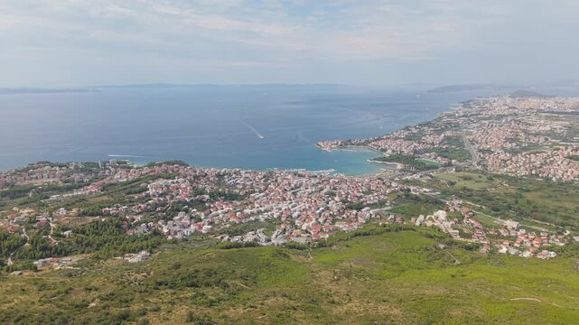Ancient stone chapel on a coastal mountain ridge with panoramic sea view of the Dalmatian coast.