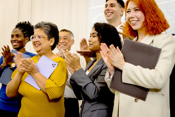 Group of diverse businesspeople clapping hands in admiration while standing together. Happy cheerful business multiethnic coworkers clap hands to celebrate the success. Smiling confident business team
