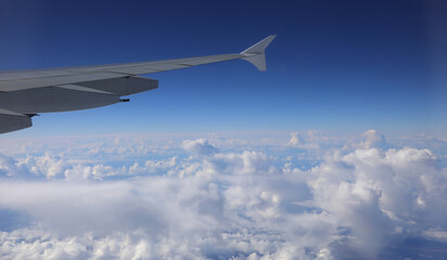 Obraz premium clouds at 40000 feet elevation from the plane looking at a part of the wing