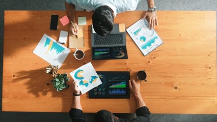 Male leader use laptop to analysis graph while marketing team working on tablet and looking at...